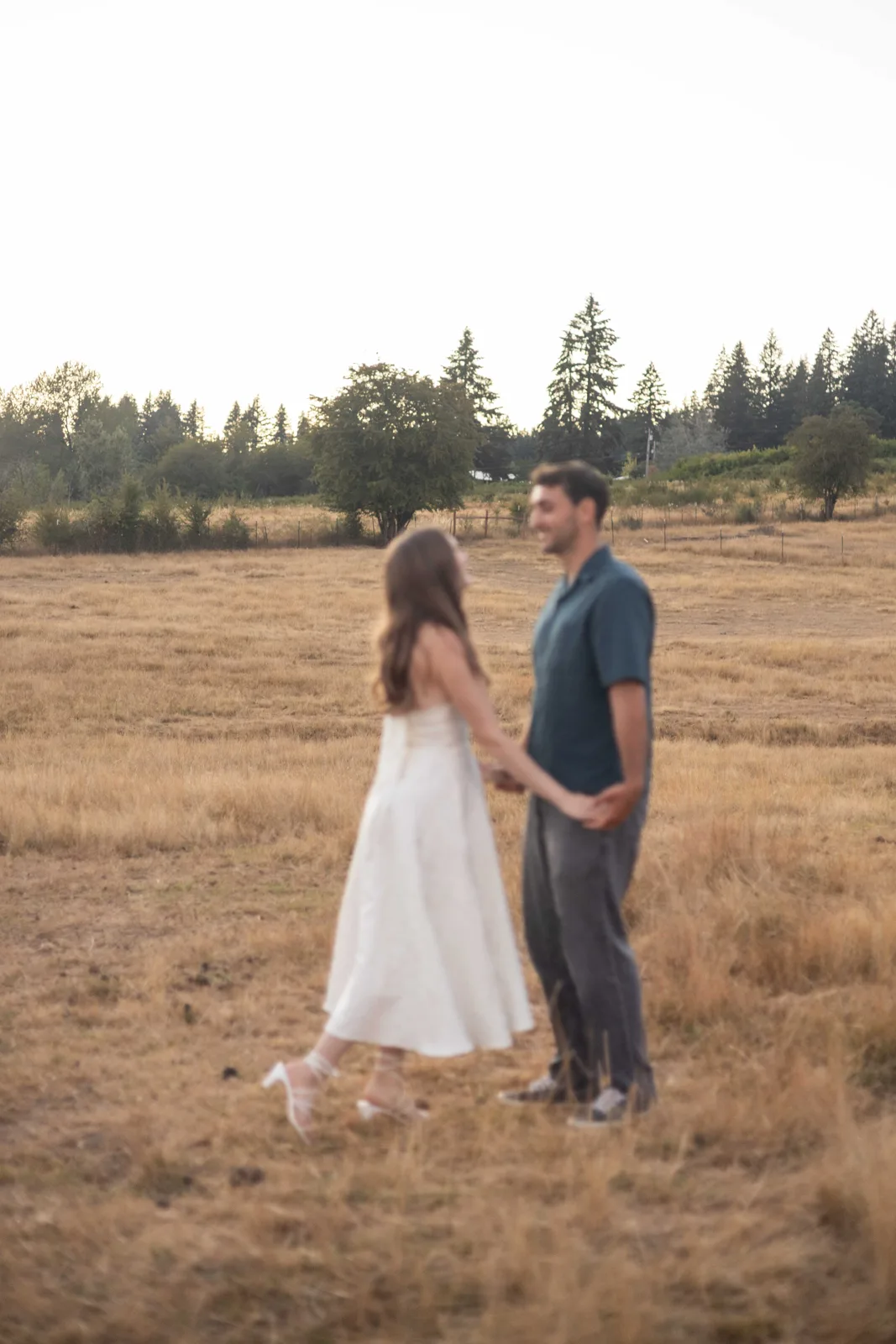 Couple holding hands walking through the field