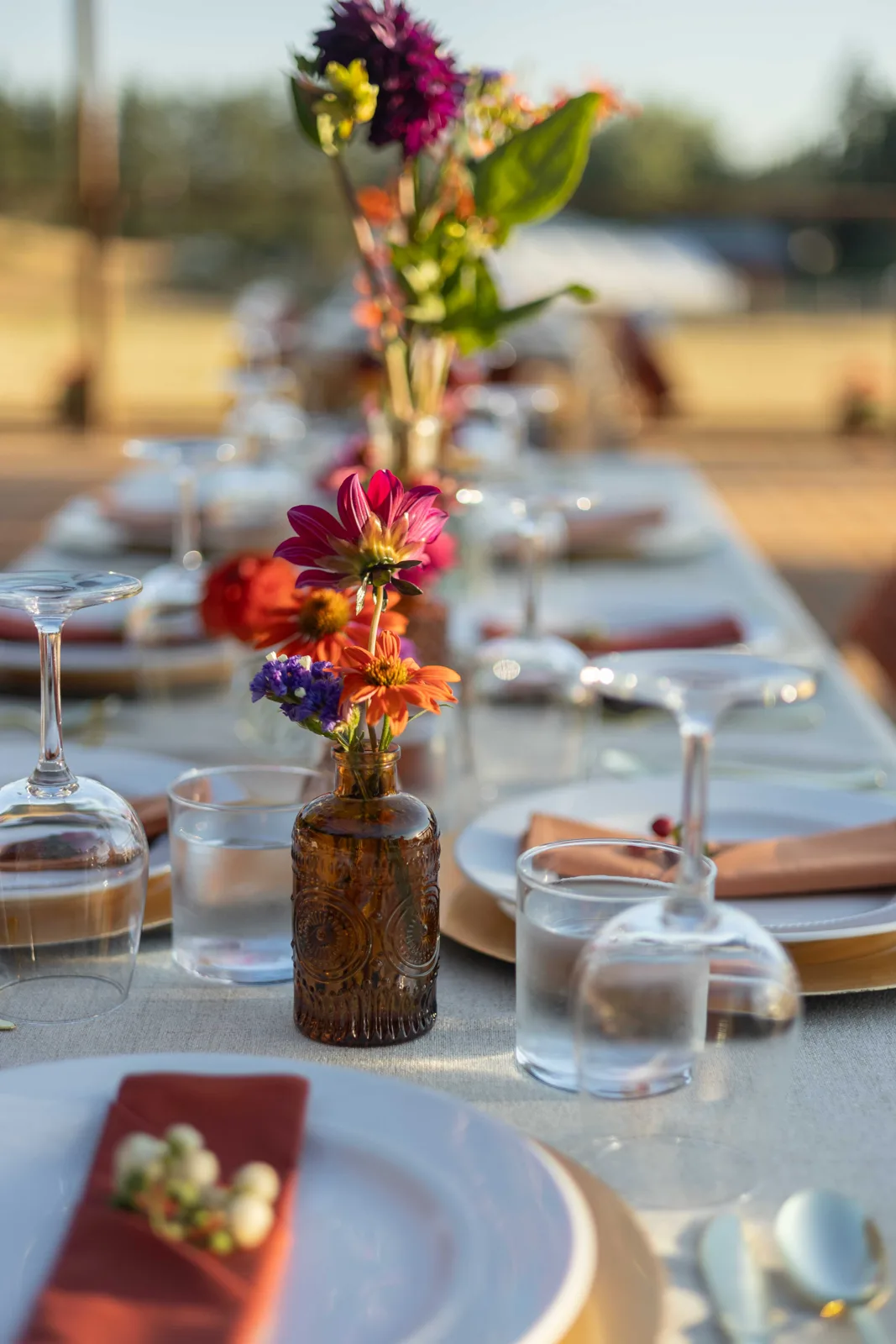 Amber glass vase with bright dahlias on a set table