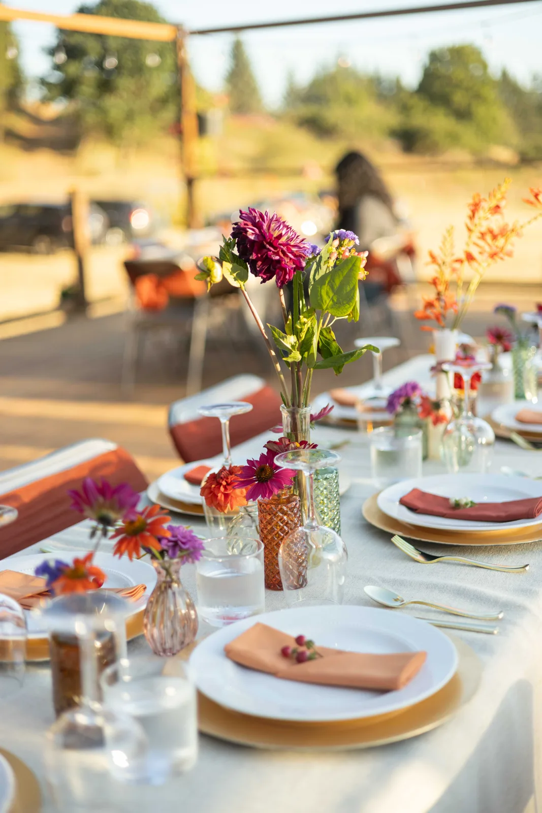 Set tables on the deck with guests gathering in the background